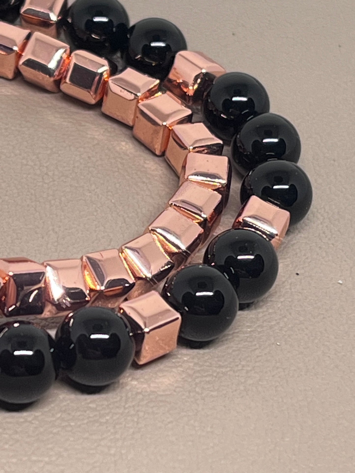 Armbånd to stk: ett roségullog ett med rosegull og sort onyx