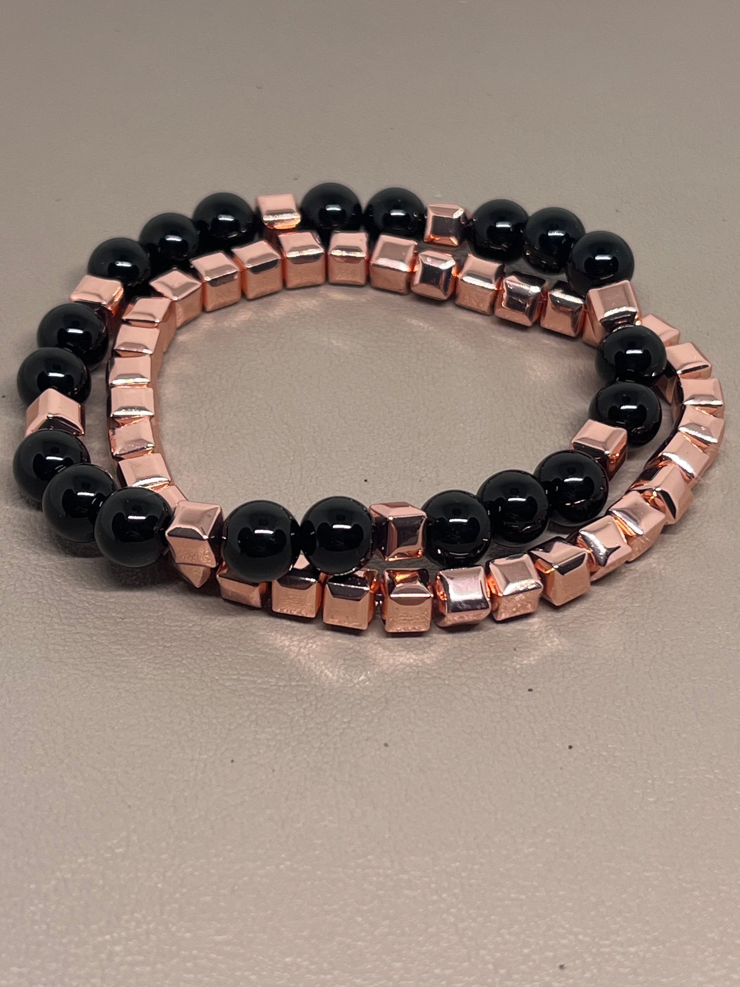 Armbånd to stk: ett roségullog ett med rosegull og sort onyx