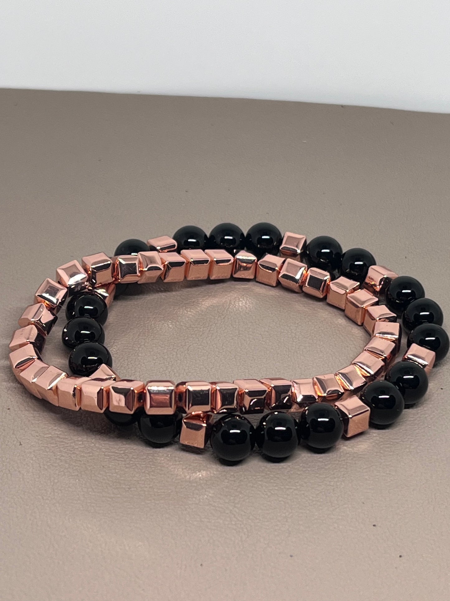 Armbånd to stk: ett roségullog ett med rosegull og sort onyx